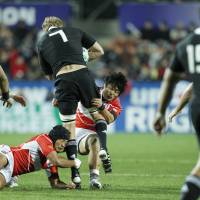 Overwhelmed: Japan hooker Yusuke Aoki (left) and flanker Itaru Taniguchi tackle All Blacks flanker Adam Thomson at the Rugby World Cup on Friday. New Zealand beat Japan 83-7. | AKI NAGAO