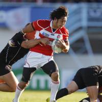 Valiant effort: Japan wing Kensuke Endo breaks through the Canadian defense at the Rugby World Cup in their Pool A match on Tuesday. The teams fought to a 23-23 draw. | AKI NAGAO