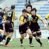 Attack mode: Suntory Sungoliath captain Juntaro Takemoto carries the ball through the Panasonic Wild Knights defense during the Top League playoff final on Sunday in Tokyo. Suntory defeated Panasonic 47-28. | YUKA SHIGA