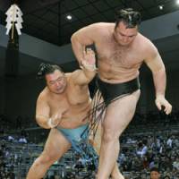 This way out: Top-ranked maegashira Toyonoshima bundles ozeki Kotooshu out of the ring at the Kyushu Grand Sumo Tournament on Wednesday. | KYODO PHOTO