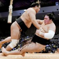 Bull rush: Komusubi Aminishiki pushes down fellow komusubi Goeido to improve to 5-1 on Friday at Fukuoka Kokusai Center during the Kyushu Grand Sumo Tournament. | KYODO PHOTO