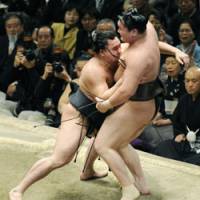 Upset: Harumafuji forces out yokozuna Hakuho to hand him his first loss at the New Year Grand Sumo on Tuesday. | KYODO PHOTO