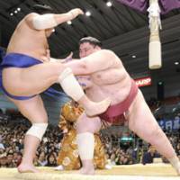Force out: Yamamotoyama pushes Toyozakura out of the ring at the Spring Grand Sumo Tournament in Osaka on Wednesday for a share of the lead at 4-0. | KYODO PHOTO