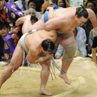 Air time: Harumafuji throws Baruto out of the ring at the Spring Grand Sumo Tournament on Thursday. | KYODO PHOTO