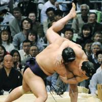 On the brink: Tochiozan pushes Harumafuji to the limit at the Spring Grand Sumo Tournament on Friday. | KYODO PHOTO