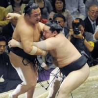 Strictly business: Asashoryu takes care of Chiyotaikai at the Summer Grand Sumo Tournament on Monday. | KYODO PHOTO