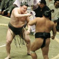Man in charge: Yokozuna Hakuho shoves Chiyotaikai out of the ring on the 10th day of the Summer Grand Sumo Tournament at Ryogoku Kokugikan on Tuesday. | KYODO PHOTO