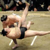 Powerful throw: Ozeki Harumafuji (above) slams yokozuna Asashoryu to the ground on Saturday. | KYODO PHOTO