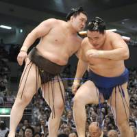 Another one bites the dust: Hakuho eases Kakuryu out of the ring on Monday. | KYODO PHOTO