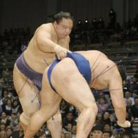 Strictly business: Kaio (left) demonstrates his strength in a victory over Kakuryu during the Kyushu Grand Sumo Tournament on Friday in Fukuoka. | KYODO PHOTO