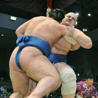 Push and pull: Baruto (rear) tussles with Tochinoshin at the Kyushu Grand Sumo Tournament in Fukuoka on Monday. | KYODO PHOTO