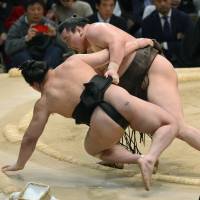 Top class: Hakuho (right) takes down Harumafuji on the final day of the Spring Grand Sumo Tournament on Sunday. | KYODO
