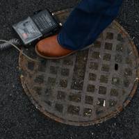 Low-level leak: Bob Ackley uses a combustible gas indicator to test for escaping methane in the Spring Valley neighborhood of Washington in February. | THE WASHINGTON POST