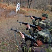 No love lost: North Korean soldiers take aim at a target featuring an image of South Korean Defense Minister Kim Kwan Jin at an undisclosed location on Saturday. | AFP-JIJI