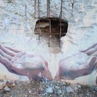 Hands-on response: A picture is painted below a blast hole from a North Korean shell that was fired at South Korea\'s Yeonpyeong Island on Nov. 23, 2010. The wall is on the side of a community soccer stadium. | THE WASHINGTON POST