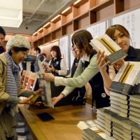 Hot off the press: Fans of Haruki Murakami buy his newly published book, \"Colorless Tsukuru Tazaki and the Year of his Pilgrimage,\" at a bookstore in Tokyo on April 12. The store started selling the books for Murakami fans at midnight. | AFP-JIJI