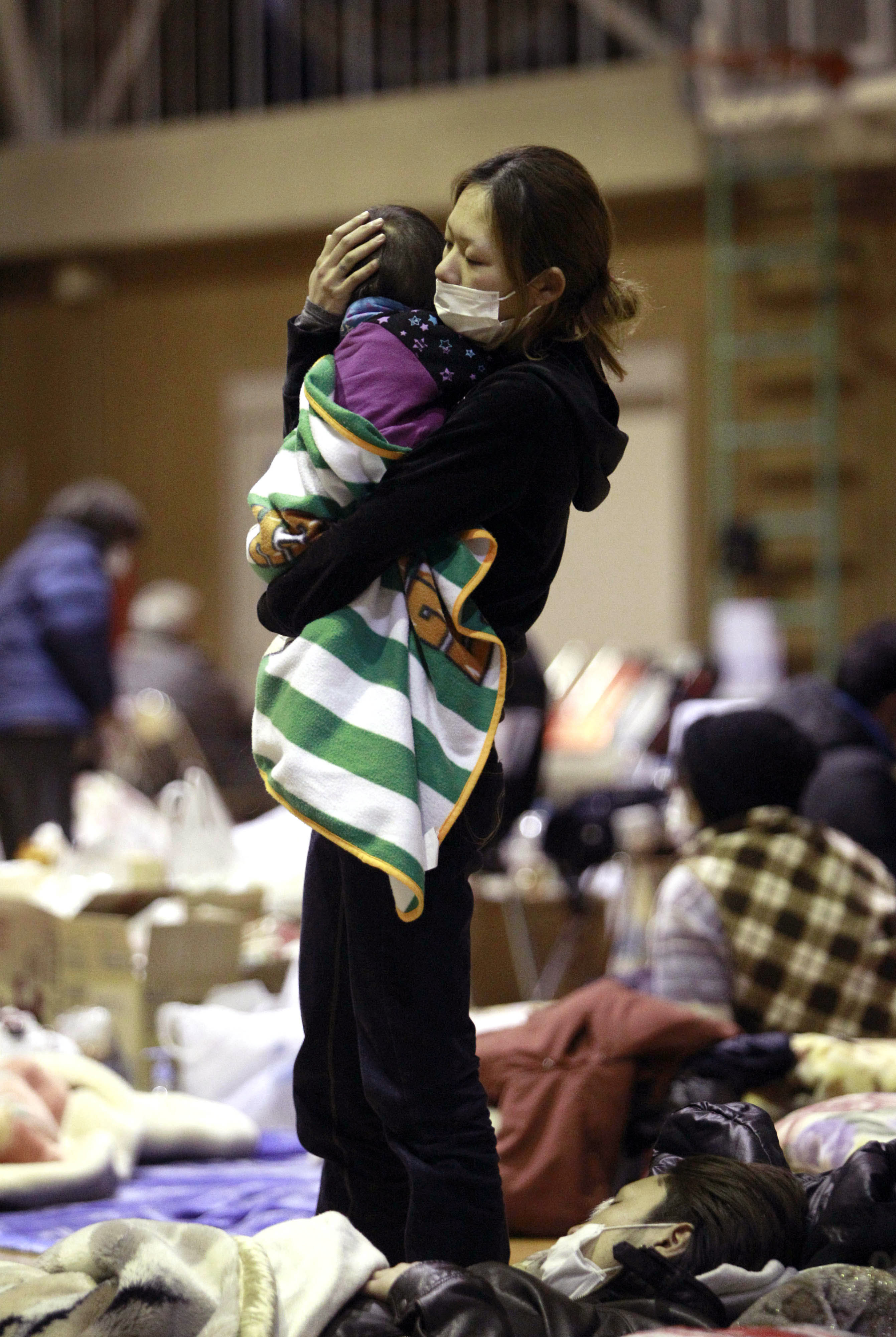Especially vulnerable: A woman holds her child at a shelter in Fukushima city after being evacuated from an area near the Fukushima No. 1 nuclear plant a few days after the March 11, 2011,  earthquake and tsunami. | AP