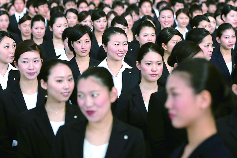 Japan Airlines Co. (JAL) group companies' new employees attend a welcoming ceremony at the company's hangar near Haneda Airport in Tokyo on April 1. | BLOOMBERG