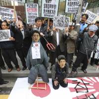 Keeping the fire stoked: Members of South Korean conservative civic groups prepare to burn an effigy of Prime Minister Shinzo Abe in front of the Japanese Embassy in Seoul on Thursday as part of a protest against visits by a record number of Japanese lawmakers last week to Tokyo’s contentious Yasukuni Shrine. Stand up to Abe for the sake of Japan, Asia's future