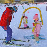 Different strokes: Before trying the Snow Park in front of Appi Kogen Snow Resort\'s main tower, splendidly kitted-out kids give their divided attention to one of its many instructors. | CHRISTOPHER JOHNSON PHOTO