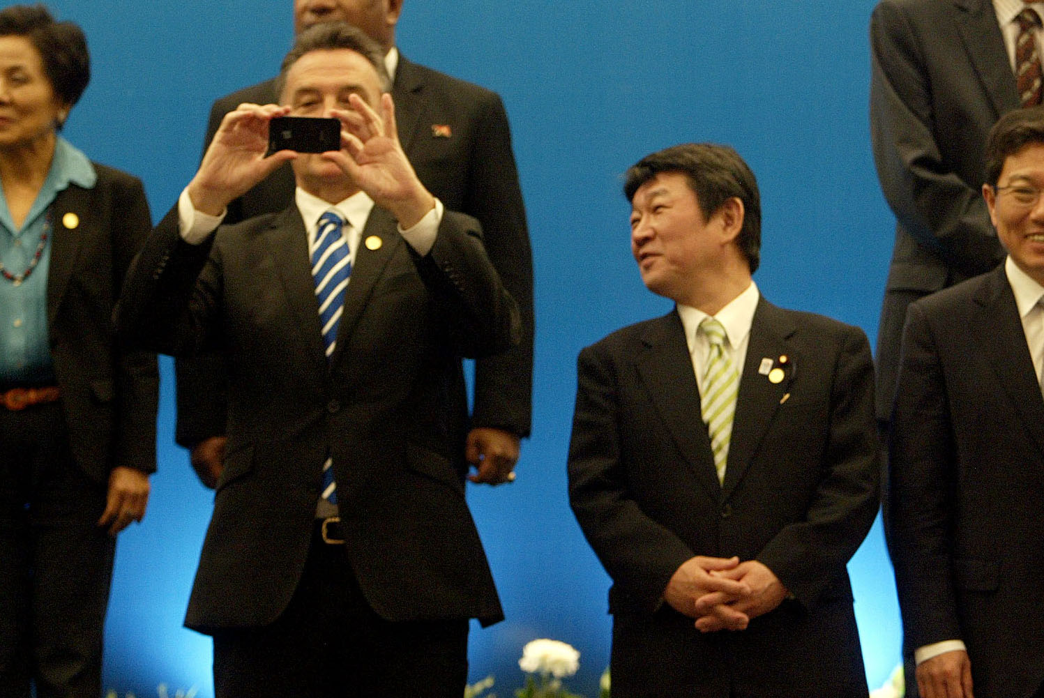 Inside looking out: Australian trade minister Craig Emerson takes a photo with his mobile phone as his Japanese counterpart, Toshimitsu Motegi, looks on during a photo session after the APEC trade ministers' meeting in Surabaya, Indonesia, on Saturday. | AFP-JIJI