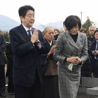 A time to pray: Incoming Prime Minister Shinzo Abe and his wife visit the grave of his father, former Foreign Minister Shintaro Abe, on Saturday in Nagato, Yamaguchi Prefecture. | KYODO