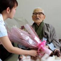 Milestone: Jiroemon Kimura receives flowers Friday at a hospital in Kyotango, Kyoto Prefecture, after he became the world\'s longest-lived man, reaching the age of 115 years and 253 days to top the previous Guinness record by a day. | KYODO