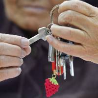Turnkey: A woman holds the key to a new public housing unit in the town of Yamamoto, Miyagi Prefecture, Monday. Her strawberry key chain reflects a specialty of the town. | KYODO