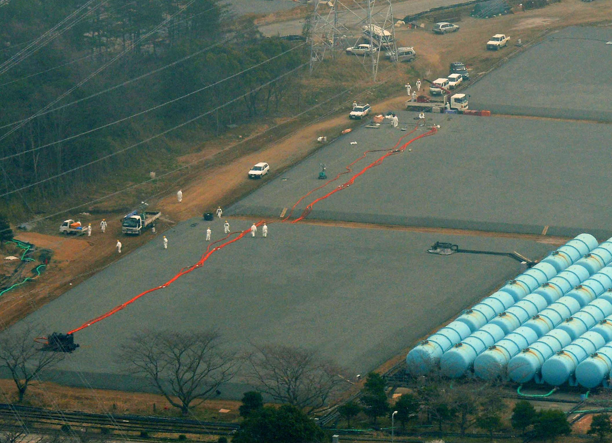 Where did it go?: Workers examine an underground tank Saturday that leaked 120 tons of highly radioactive water at the Fukushima No. 1 nuclear plant in the town of Okuma. | KYODO