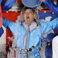Victorious: Supporters of Nagoya Mayor Takashi Kawamura dump a celebratory bucket of water on him Sunday after deciding from early returns that their bicycle-riding tax cutter had won re-election. | KYODO