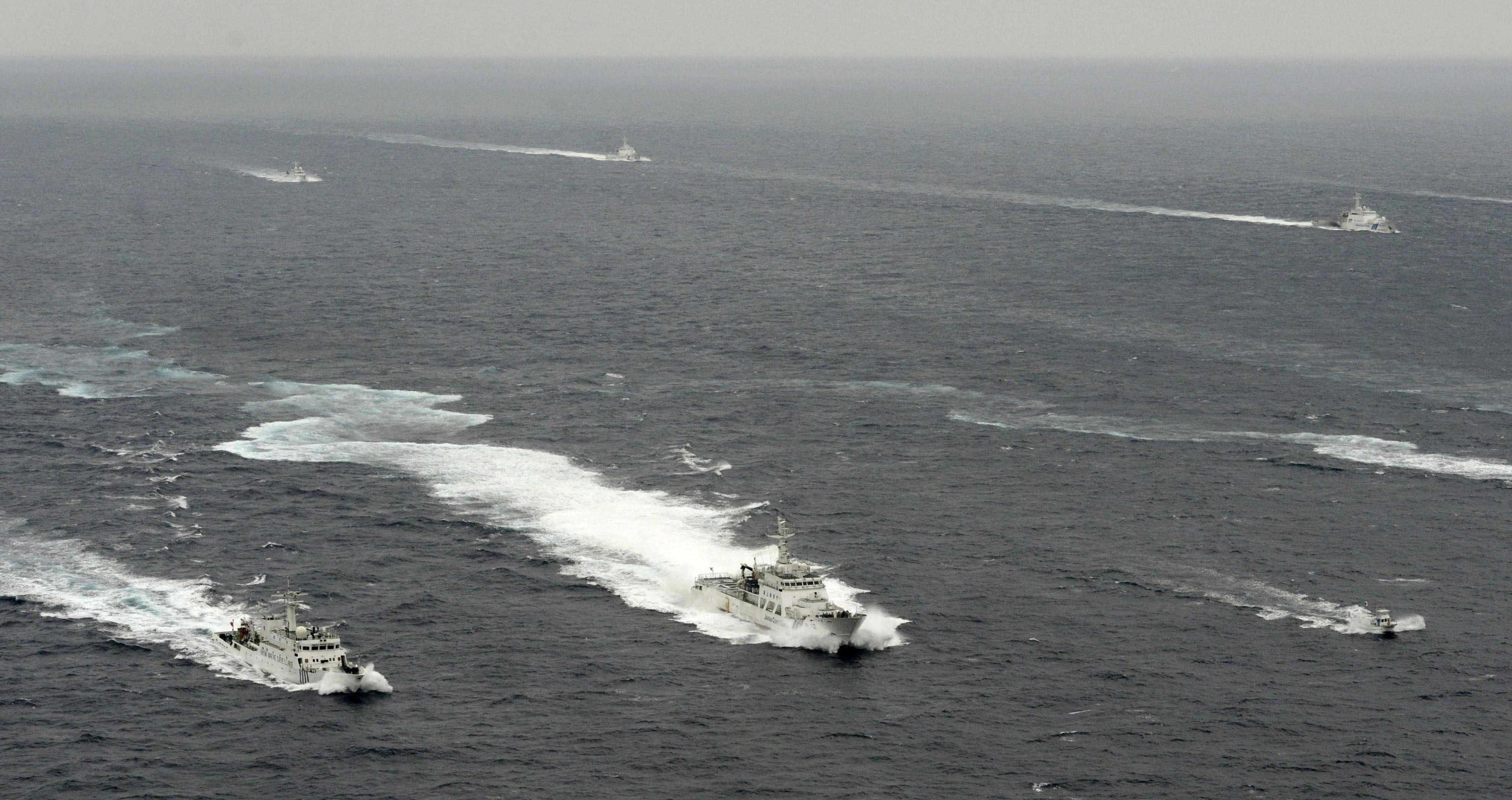 Rocking the boat: Ships from China's State Oceanic Administration, the Japan Coast Guard and boats carrying members of a Japanese nationalist group sail in Japanese territorial waters around the Senkaku Islands on Tuesday morning. In the foreground, a Japan Coast Guard cutter stays between a Chinese vessel at left and a boat carrying the nationalists. | KYODO