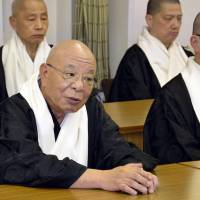 Hosed: Kosho Shono (left), leader of Koyasan Shingon Buddhism, speaks at a press conference Wednesday at the temple\'s headquarters in Koya, Wakayama Prefecture. Shono announced his resignation to take responsibility for financial losses at the temple, which saw about a quarter of its assets vanish as bets on the Australian dollar and structured bonds soured. | KYODO