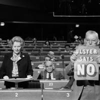 Margaret Thatcher addresses the European Parliament in Strasbourg in December 1986 as Democratic Unionist Party leader Ian Paisley brandishes a placard reading: \"Ulster says no.\"  | AFP-JIJI