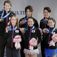 Team effort: Japanese figure skaters stand together during the awards ceremony after receiving their third-place medals at the World Team Trophy on Saturday. | KYODO