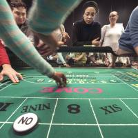 Maintaining focus: From left, students Carl Smith, Karl Kim and Dana Trantham work the craps table while student Ashley Fletcher observes during class at the Casino Dealer School in Glen Burnie, Maryland, on Feb. 28. Dealers are needed as new live-action table games launch in Maryland on Thursday. At dealer school, job seekers roll the dice for a casino gig