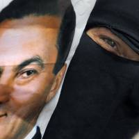 The good old days?: An Egyptian woman holds a poster of ousted President Hosni Mubarak during a demonstration outside the Supreme Administrative Court in Cairo on Monday.  The court says it does not have jurisdiction to rule on a case launched by supporters of Mubarak who challenged the legality of his removal from power two years ago. | AP