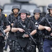 Defend the homeland: A SWAT team marches through a neighborhood while searching for a suspect in the Boston Marathon bombing in Watertown, Massachusetts, on Friday. Boston attack exposes limitations of post-9/11 security buildup