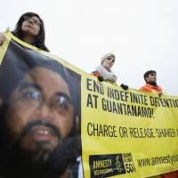 Still behind bars: Activists hold a banner with a photo of Guantanamo detainee Shaker Aamer, at a rally in Washington on Jan. 11. Captured by U.S. forces in Afghanistan in 2001, Aamer has been imprisoned for the past 12 years without being charged. | AP