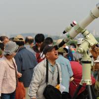 A man gets an eyeful via a shared telescope brought by the Tegahoshimitai group.  | Sofia Elghazzali 
