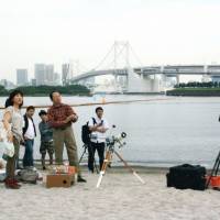 hotographers ready their equipment at Odaiba Beach, Tokyo, in preparation for the solar eclipse. | Mads Berthelsen