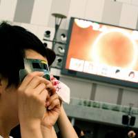 A large screen in Odaiba, Tokyo shows a Fuji TV broadcast of the solar eclipse. | Mads Berthelsen