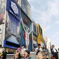 A crowd in downtown Osaka take a bare-eyed chance. | KYODO