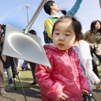 A child views the eclipse up close at the Gunma Prefectural Astronomical Observatory. | KYODO
