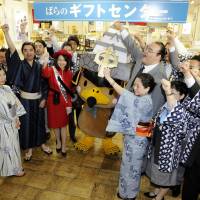 Employees from Tokyo\'s Nihonbashi Takashimaya department store dressed in \"yukata\" summer kimono and happi coats are joined Wednesday by sumo stablemaster Furiwake (center right) and an unidentified character in a cheer to kick off the annual fair for the summer gift-giving season. | KYODO