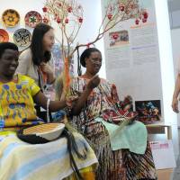 Rwandan women demonstrate how to weave traditional baskets, which are exported to Japan, at African Fair 2013 in Yokohama on Thursday. The fair will run through Sunday. | SATOKO KAWASAKI