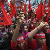Fashion victims: Women protesters shout slogans calling for better working conditions for garment workers during a May Day rally on May 1 in Dhaka, Bangladesh. Thousands of garment factory workers paraded through the streets of the city calling for safeguards to be put in place after a factory building collapsed last month, killing more than 1,100 people. | AP