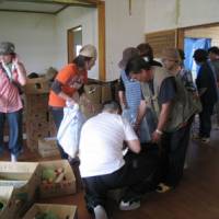 the volunteers hand donated vegetables to residents, who are still short of fresh produce. | STEPHEN MANSFIELD PHOTO