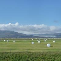 Bales of hay wrapped in plastic lend a sci-fi look to these fields in southern Iceland. | KEI MIYAJIMA PHOTO/(C) AIDA MAKOTO/COURTESY MIZUMA ART GALLERY