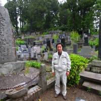 His son (right) stands by one of Taro\'s two \"tsunami stones,\" erected to mark the disasters of 1896 and 1933. | MAMI MARUKO PHOTO