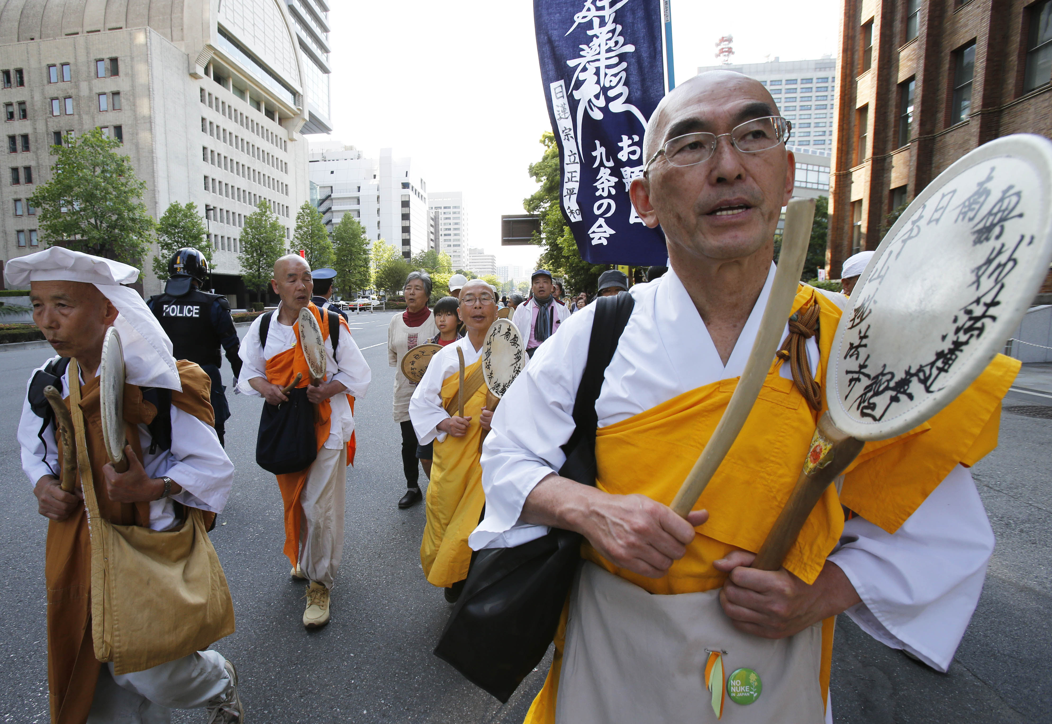 Off the warpath: Buddhist monks participate in a march against Prime Minister Shinzo Abe's calls to amend the war-renouncing Constitution in Tokyo on the Constitution Day holiday Friday. Hundreds of people, young and old, gathered downtown for a peaceful protest against Abe's efforts to give the government more power to abridge civil liberties. | AP